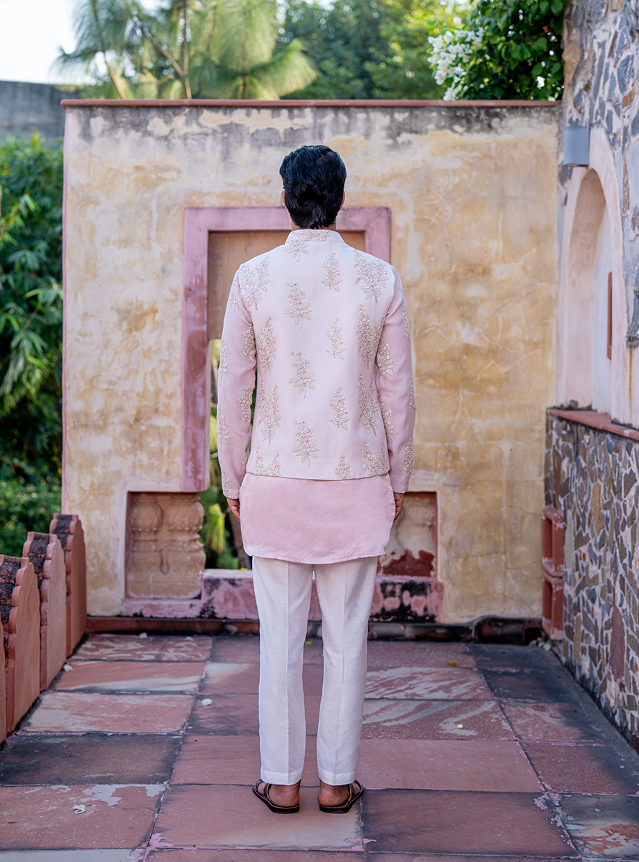 PASTEL PINK SATIN LINEN KURTA WITH CHANDERI PASTEL PINK FLORAL EMBROIDERED SLEEVES PAIRED WITH PASTEL PINK FLORAL EMBROIDERED BUNDI + WHITE SATIN LINEN PANT Nafsstore