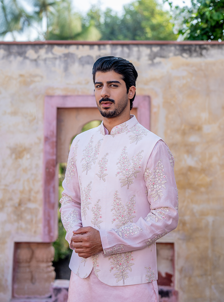 PASTEL PINK SATIN LINEN KURTA WITH CHANDERI PASTEL PINK FLORAL EMBROIDERED SLEEVES PAIRED WITH PASTEL PINK FLORAL EMBROIDERED BUNDI + WHITE SATIN LINEN PANT Nafsstore