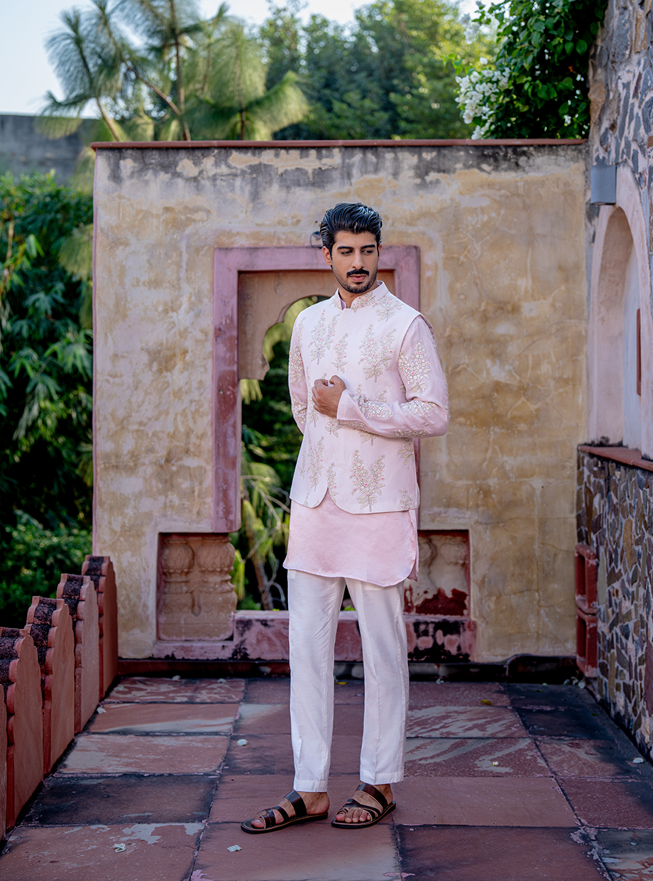 PASTEL PINK SATIN LINEN KURTA WITH CHANDERI PASTEL PINK FLORAL EMBROIDERED SLEEVES PAIRED WITH PASTEL PINK FLORAL EMBROIDERED BUNDI + WHITE SATIN LINEN PANT Nafsstore