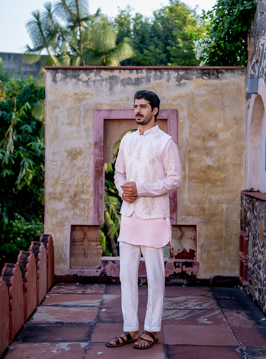 PASTEL PINK SATIN LINEN KURTA WITH CHANDERI PASTEL PINK FLORAL EMBROIDERED SLEEVES PAIRED WITH PASTEL PINK FLORAL EMBROIDERED BUNDI + WHITE SATIN LINEN PANT Nafsstore