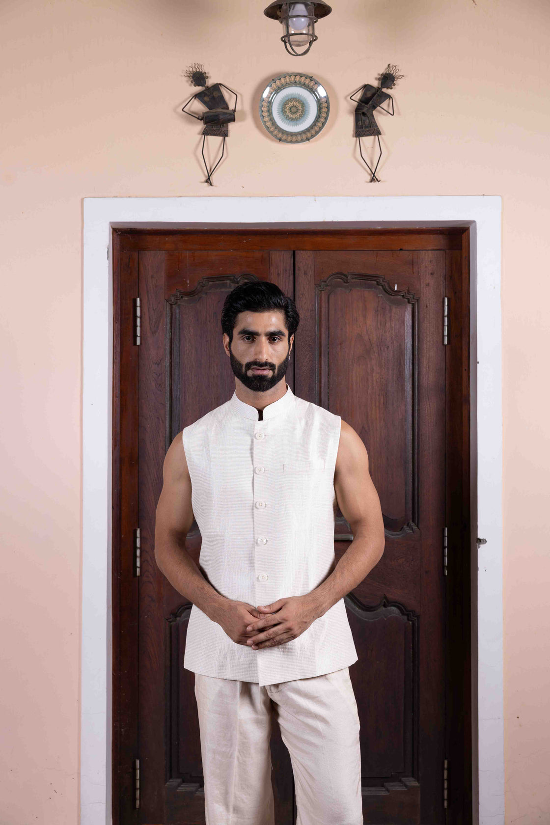 Soft pink tussar silk long jacket with mughal jali inspired resham, kasab and mirror work paired with ivory textured tissue sleeveless button bundi and flared pant Nafsstore
