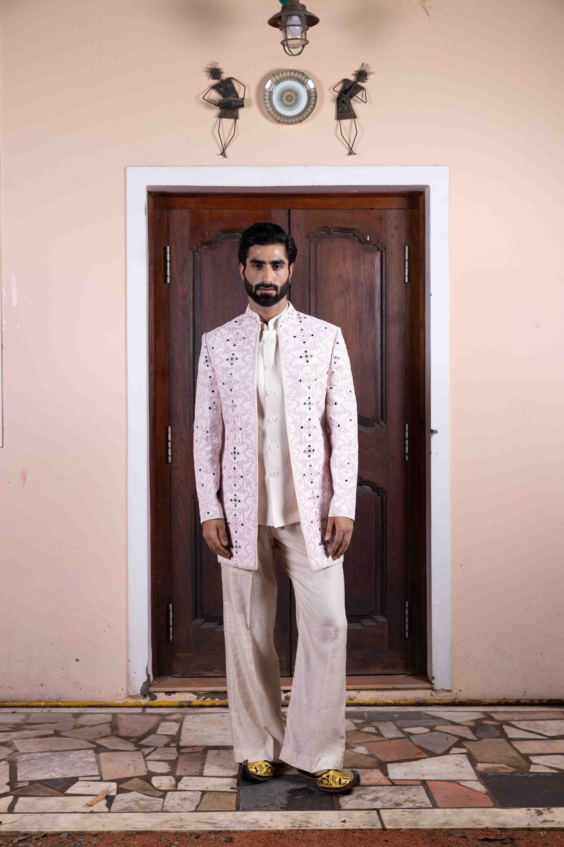 Soft pink tussar silk long jacket with mughal jali inspired resham, kasab and mirror work paired with ivory textured tissue sleeveless button bundi and flared pant Nafsstore