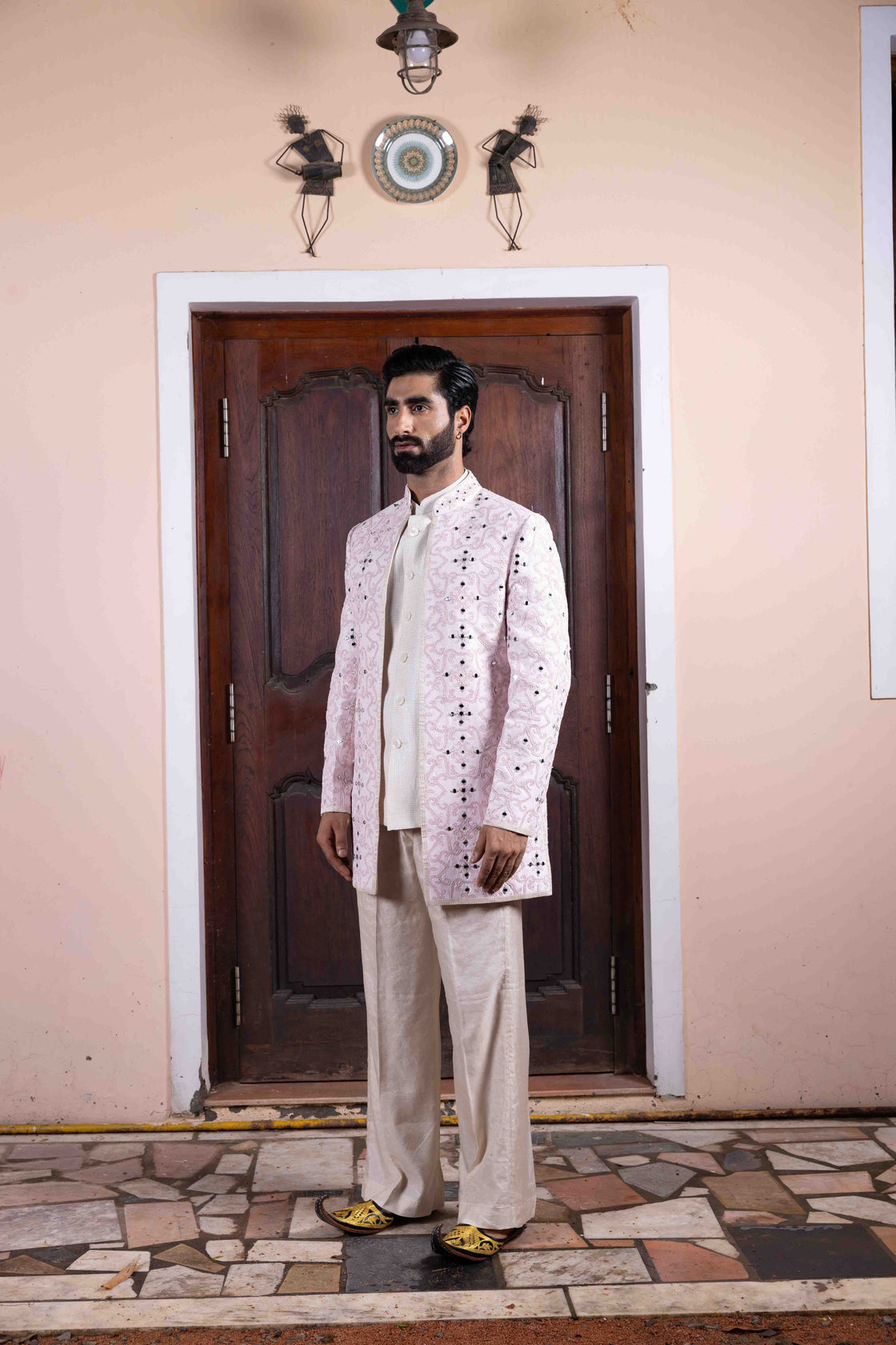 Soft pink tussar silk long jacket with mughal jali inspired resham, kasab and mirror work paired with ivory textured tissue sleeveless button bundi and flared pant Nafsstore